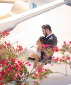 bride and groom sitting on the roof of a house in Santorini