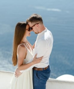 Happy couple hugging and laughing together with a view of Santorini