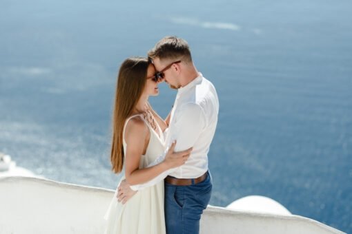 Happy couple hugging and laughing together with a view of Santorini